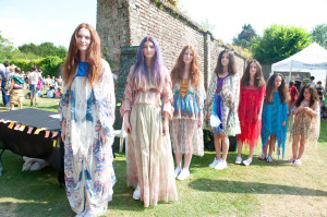 The Warren sisters and Spanier sisters preparing to go on stage in the walled garden. They all wear Zandra Rhodes, while the last in line wears Kate Moss for Topshop for Topshop, inspired by Zandra. © Fiona Campbell