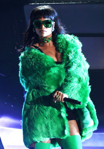 Rihanna performs onstage channelling the 1970’s look in a green Versace fur coat. Credit: Getty Images.