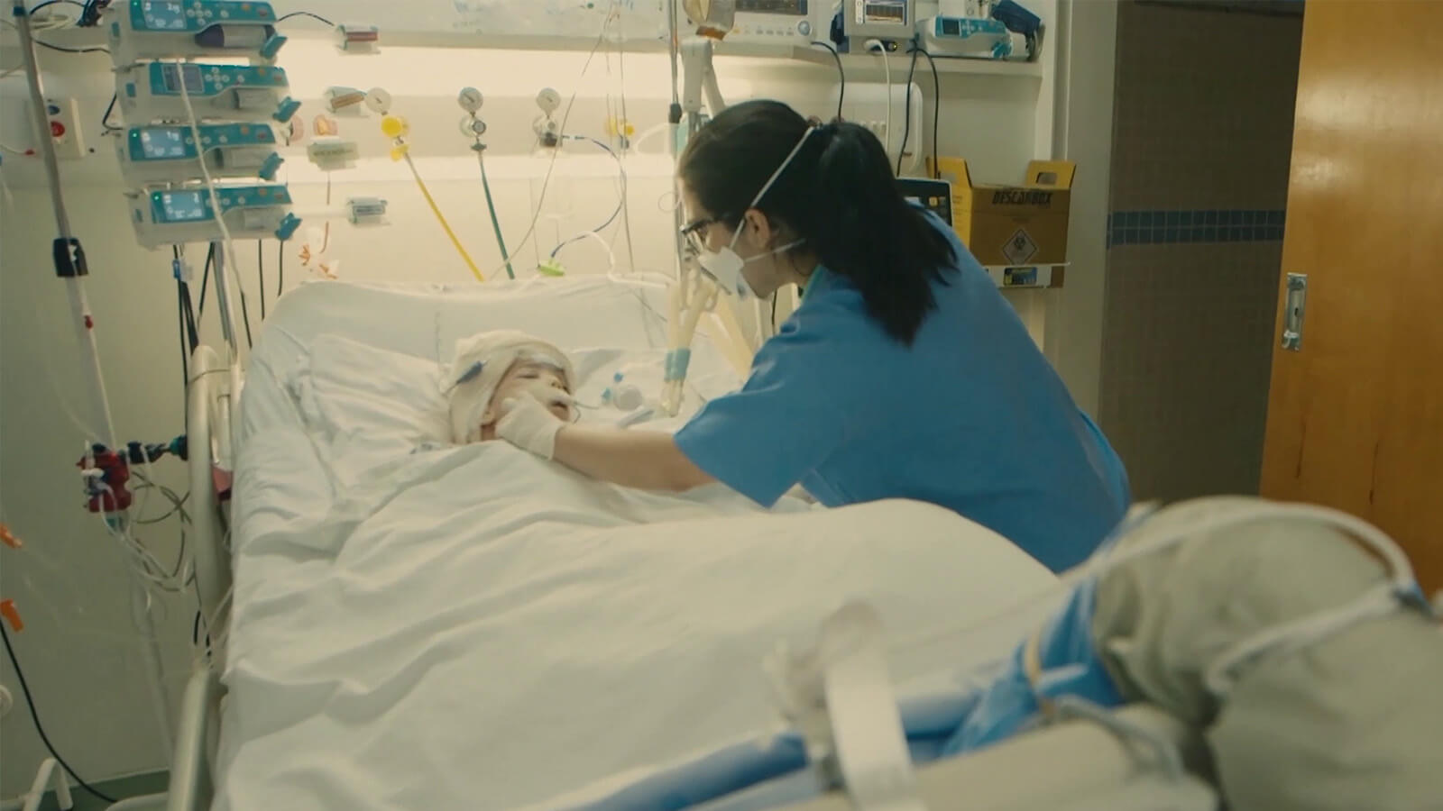 uma enfermeira a verificar a tubagem de um dos gémeos, já depois da cirurgia