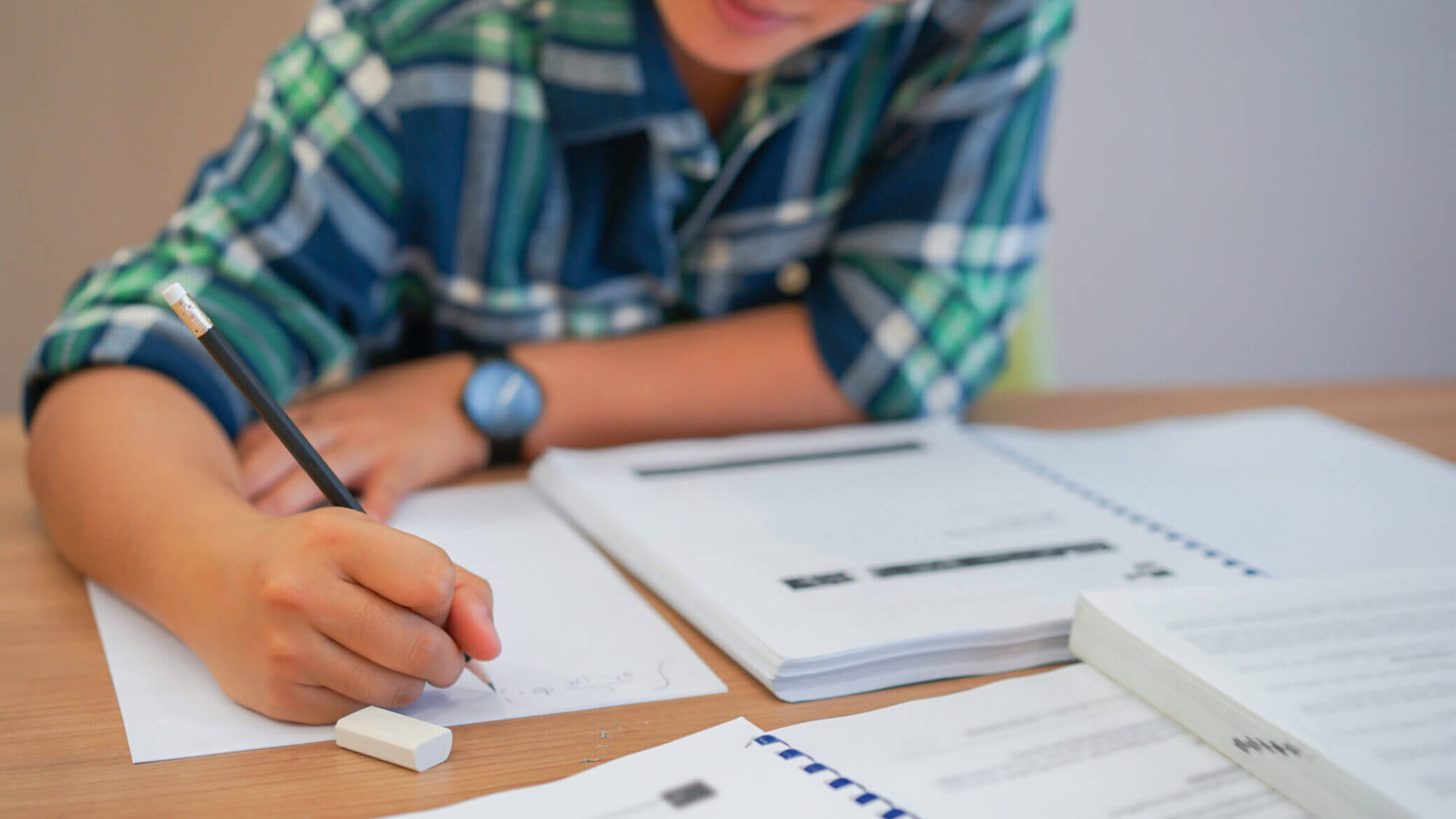 Aluno a consultar manual escolar na sala de aula