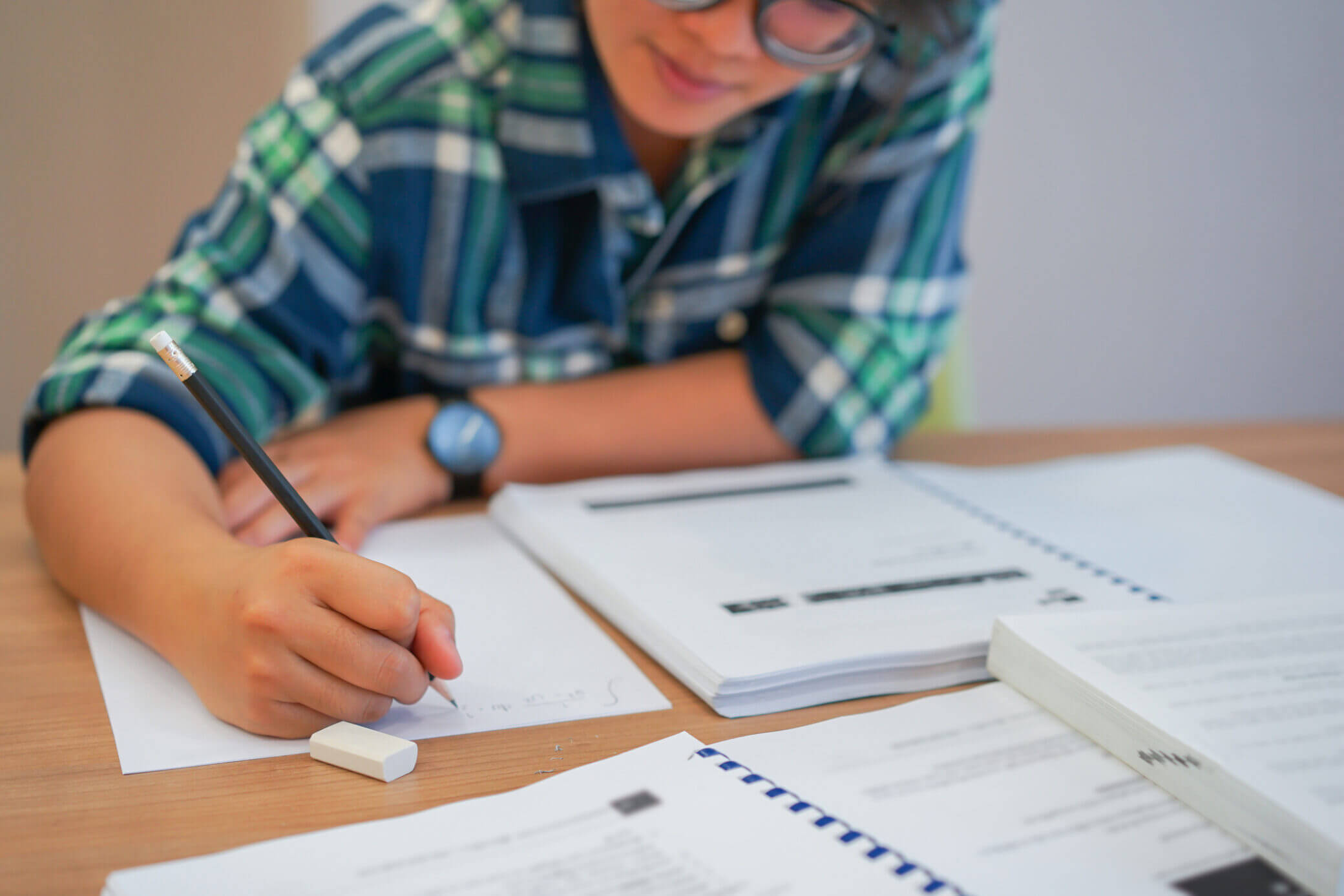 Aluno a consultar manual escolar na sala de aula
