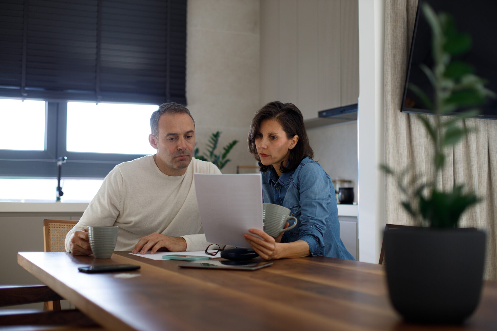 Casal sentado à mesa da cozinha a calcular os apoios a que tem direito com base no IAS.