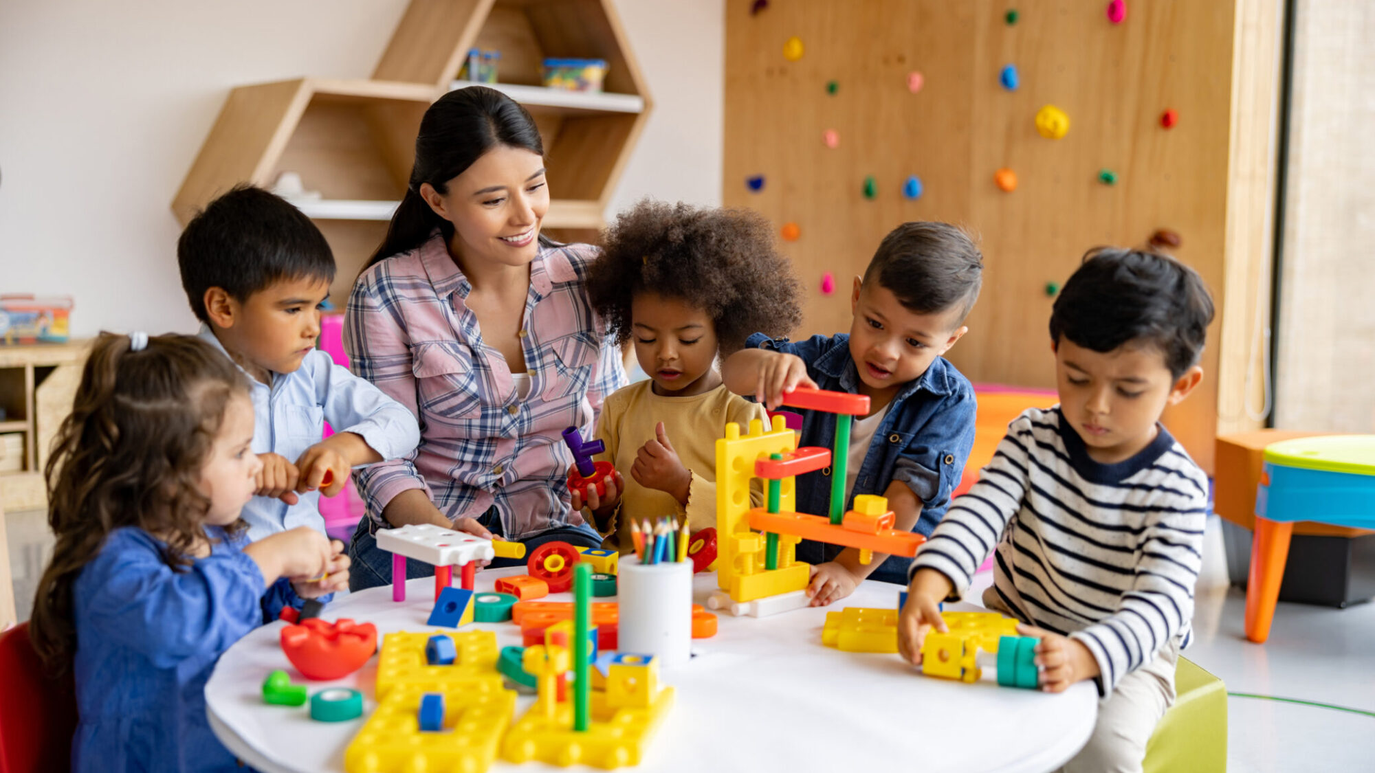 Educadora brinca com crianças numa creche gratuita do programa Creche Feliz