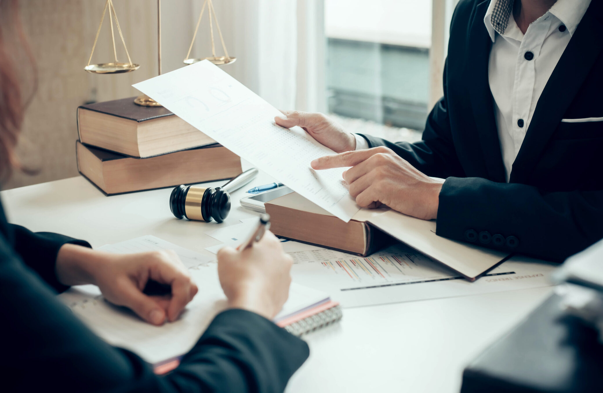Duas pessoas analisam documentos legais sobre uma mesa, simbolizando a consulta e obtenção de registo criminal em Portugal.